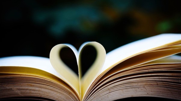Open book with page curled into a heart shape